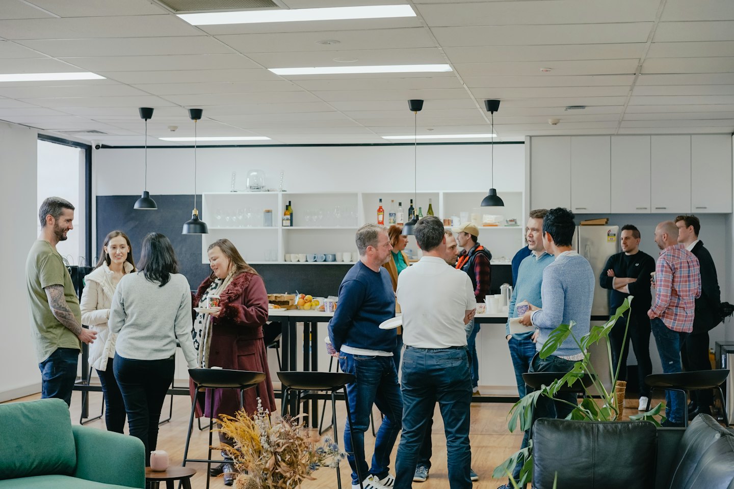 Professionals die netwerken en socializen in een moderne kantoorlounge.